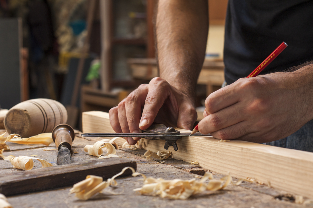 A tradesman working with a piece of wood.